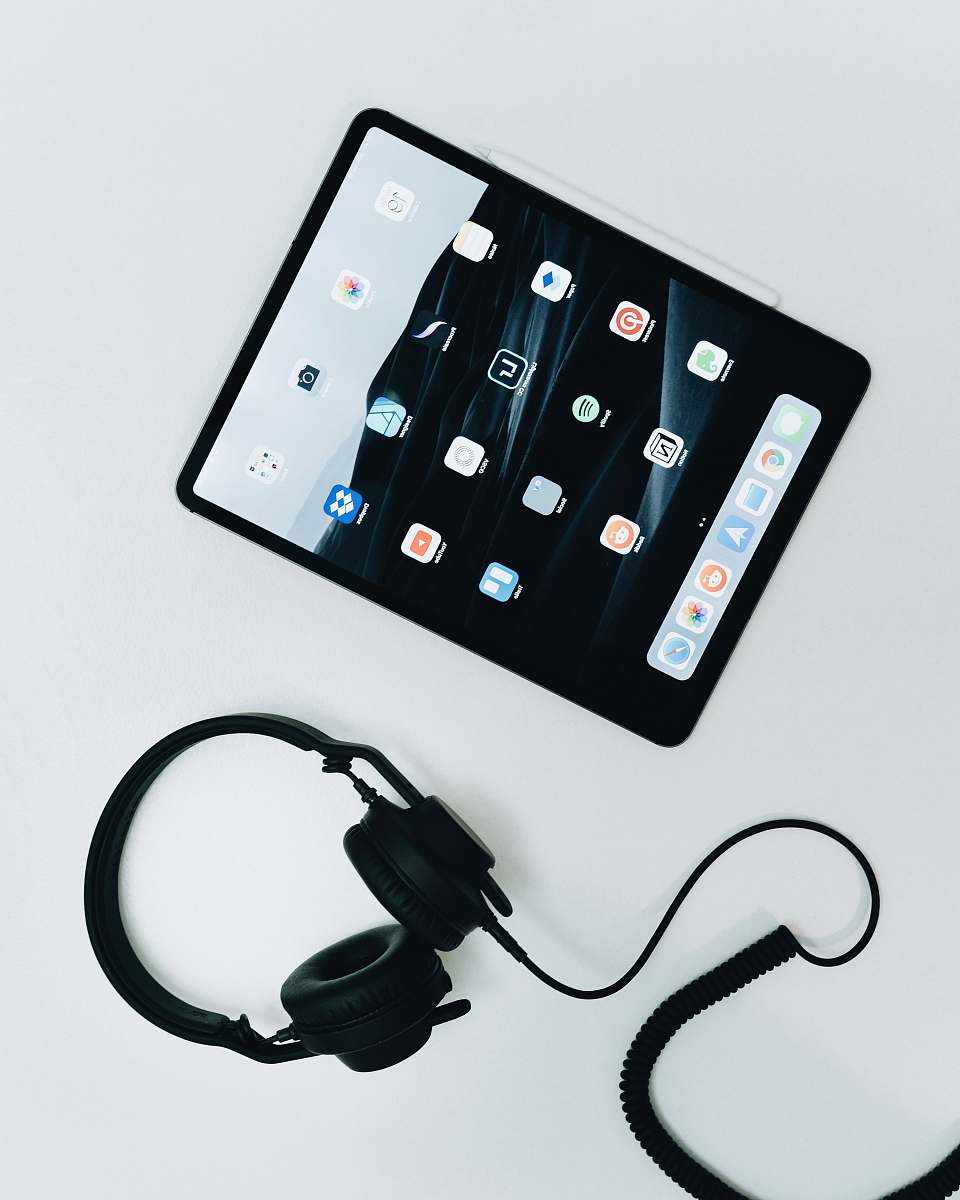 electronics flat lay photo of black iPad and corded headphones mobile phone